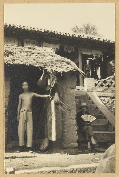Guanyanling关隘附近岩壁寺庙前的三人